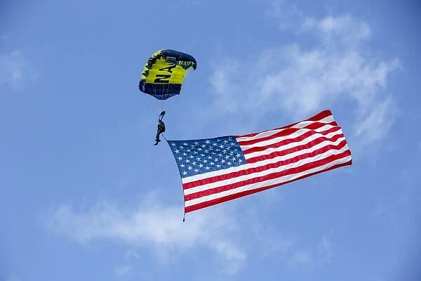 Member of the U. S. Navy Parachute Team flies the American Flag