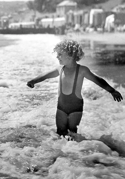 Brave young girl goes for a paddle in the sea while on holiday Circa 1945