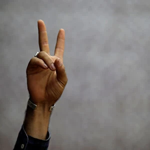 A Kurdish man flashes a sign of solidarity during a moment of silence in memory of the
