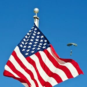 A member of the Armyas Black Daggers parachute team passes by the American flag